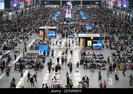 Vista ad alto angolo dei viaggiatori nella stazione ferroviaria di Shanghai Hongqiao durante il giorno Nazionale della Cina. Persone che indossano maschera viso per prevenire il coronavirus Foto Stock