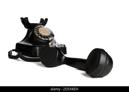 Telefono nero vintage con ricevitore sganciato su sfondo bianco, messa a fuoco selettiva Foto Stock