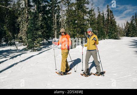 Due racchette da neve giovani donne sul monte Cappa in una giornata di sole. Foto Stock
