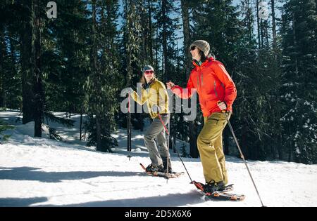 Due racchette da neve giovani donne sul monte Cappa in una giornata di sole. Foto Stock