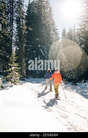 Due racchette da neve giovani donne sul monte Cappa in una giornata di sole. Foto Stock