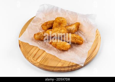 ali di pollo su un piatto di legno su sfondo bianco Foto Stock