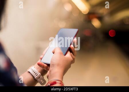 Mani donna utilizzando smartphone in sottosuolo. Mockup cellulare ragazza touchscreen. Foto Stock