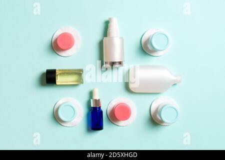 Gruppo di piccole bottiglie per viaggiare su sfondo colorato. Copia spazio per le tue idee. Composizione piatta dei prodotti cosmetici. Vista dall'alto della panna c Foto Stock