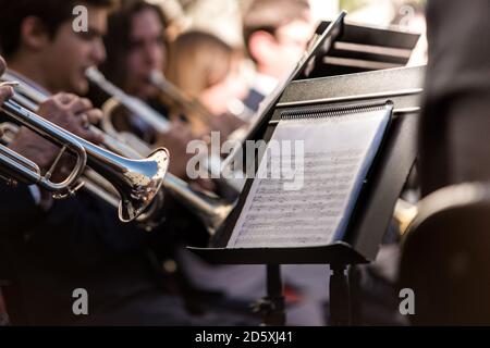 Primo piano sulla fotografia di un brano musicale sullo stand musicale. I musicisti suonano la tromba in un concerto di musica classica Foto Stock