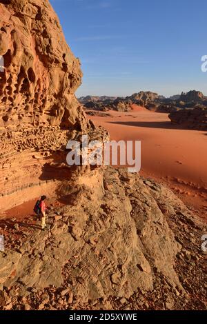 Algeria, Tassili n' Ajjer, Tadrart, Sahara, Tassili n' Ajjer National Park, donna trekking nel paesaggio roccioso del circo Foto Stock