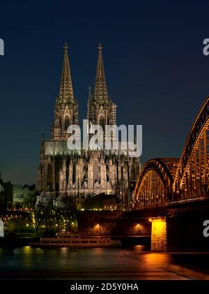 Germania, Colonia, ha illuminato la cattedrale di Colonia e il ponte di Hohenzollern di notte Foto Stock