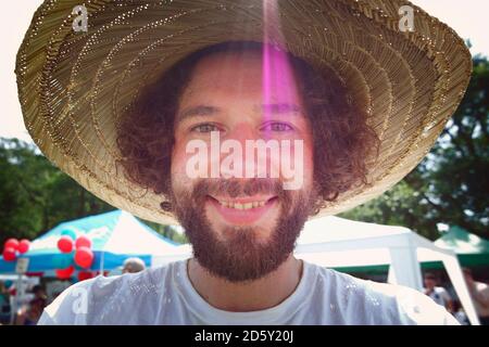 Ritratto di uomo che indossa un cappello di paglia, sorridente Foto Stock