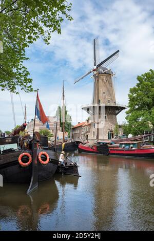 Paesi Bassi, Gouda, porto con navi a vela tradizionali e mulini a vento Foto Stock