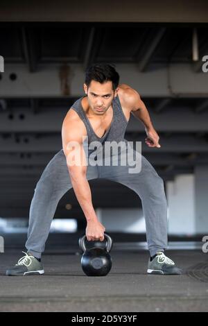 Allenamento muscolare dell'uomo con kettlebell Foto Stock