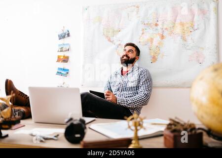 Giovani viaggiatori di pianificazione il suo prossimo viaggio da casa Foto Stock