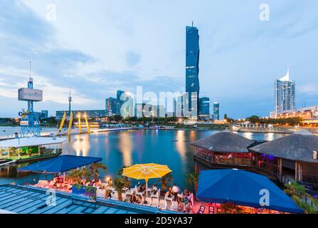 Austria, Vienna, Sunken City, Donau City, Danubio e DC Tower 1 in serata Foto Stock