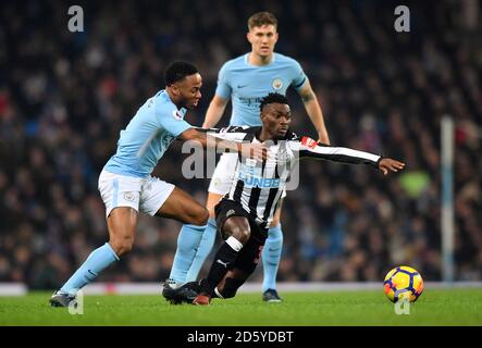 Newcastle United's Christian Atsu (centro) battaglie per la palla con Raheem Sterling di Manchester City (a sinistra) e John Stones di Manchester City Foto Stock