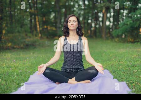 Croazia, Donna meditando in posizione di loto, yoga in natura Foto Stock