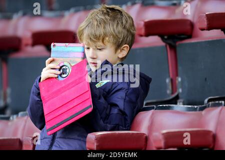 Un giovane fan con un ipad Apple sui supporti Foto Stock