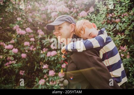 Padre che dà suo figlio un piggy indietro mentre camminando Foto Stock