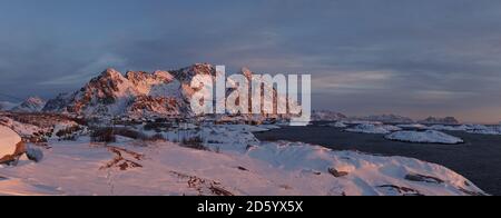 Faro allo stadio di calcio Henningsvaer durante l'alba sulle isole Lofoten in Norvegia. Foto Stock