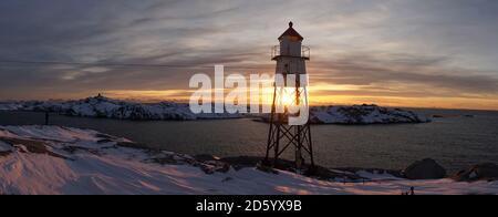 Faro allo stadio di calcio Henningsvaer durante l'alba sulle isole Lofoten in Norvegia. Foto Stock