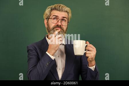 Piacevole sorso. Pausa caffè e relax. Pranzo per l'insegnante. Dose di caffeina. Concetto di ottimismo. Insegnante in bicchieri bere caffè Chalkboard sfondo. Caffè dipendente. Carica di energia per tutto il giorno. Foto Stock