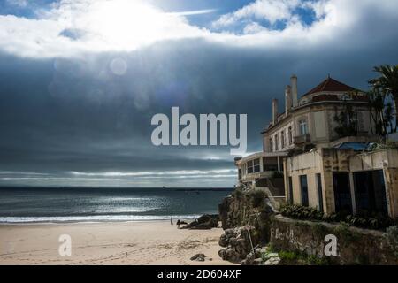 Portogallo Cascais, luce drammatica sulla spiaggia e una vecchia villa Foto Stock