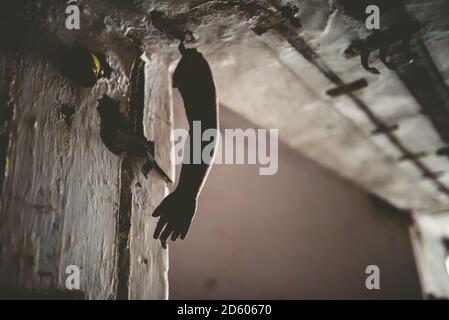 Braccio di bambola appesi al soffitto di una casa in rovina Foto Stock