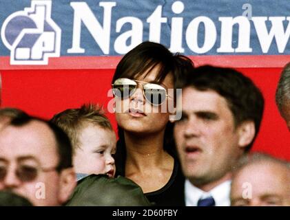 Victoria Beckham guarda suo marito David Beckham in azione su Il campo con suo figlio Brooklyn Foto Stock