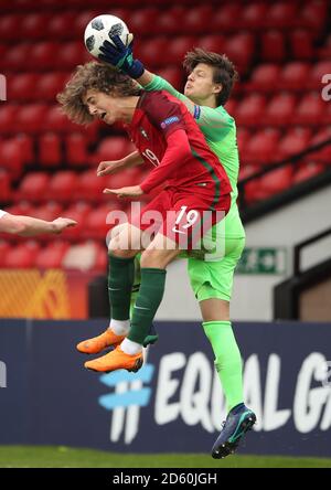 Il portiere della Norvegia U17 Rasmus Sandberg tiene la palla sopra la testa Del Portogallo U17 's Fabio Silva Foto Stock