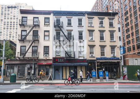 Edificio più vecchio lungo la 2nd Avenue circondato da edifici di appartamenti molto più nuovi in 33rd Street a Manhattan. Foto Stock