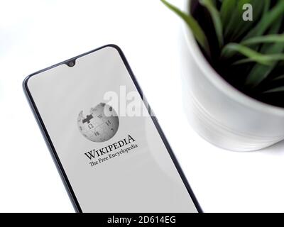 LOD, Israele - 8 luglio 2020: Moderno spazio di lavoro minimalista per ufficio con smartphone nero mobile con schermata di lancio dell'applicazione Wikipedia con logo su una parte posteriore bianca Foto Stock