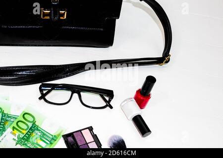 Elegante borsa con soldi e cosmetici prodotti di bellezza isolato su sfondo bianco con spazio copia. Foto Stock