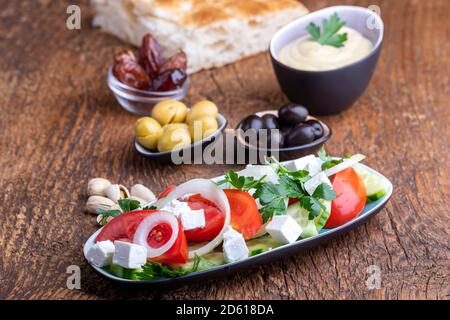 olive e hummus su legno scuro Foto Stock