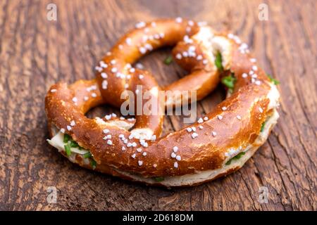 Pretzel bavarese con burro su legno Foto Stock