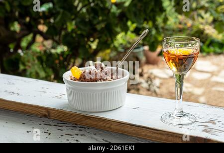 Liquore tradizionale belga alla mandarino e mousse al cioccolato, guarnita con un cuneo di mandarino e scaglie di cioccolato bianco su un davanzale contro il Foto Stock