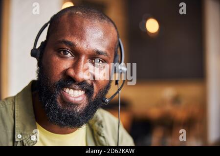 Bell'uomo afro-americano in cuffia che esprime emozioni positive Foto Stock