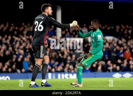 Il portiere di Watford ben Foster (a sinistra) festeggia con il compagno di squadra Abdoulaye Doucoure (A destra) dopo aver salvato una penalizzazione presa da Gylfi Sigurdsson di Everton (non in figura) Foto Stock