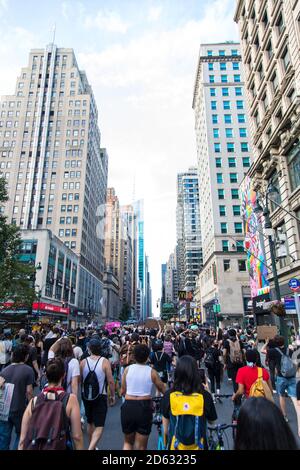 Folla di manifestanti con cartelli durante il mese di giugno, 6th Avenue, Midtown, New York City, New York, USA Foto Stock