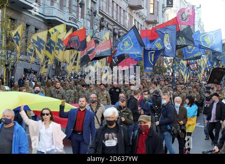 Gli attivisti ucraini di estrema destra che detengono bandiere partecipano alla marcia commemorativa del 78° anniversario della fondazione dell'esercito insurgente ucraino. L'esercito insurgente ucraino (UPA) ha combattuto per l'indipendenza Ucraina dal 1942 al 1949, per lo più in Ucraina occidentale contro i regimi nazisti e sovietici tedeschi. Gli ucraini celebrano anche la Giornata del difensore dell’Ucraina nella stessa data. Foto Stock