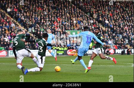 Jordy Hiwula di Coventry City (a destra) spara verso l'obiettivo Foto Stock