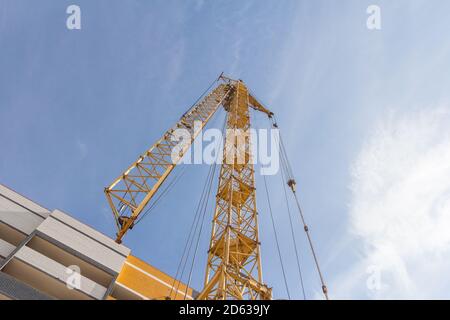 Gru a torre in cantiere. Gru a torre abbassata su sfondo cielo Foto Stock