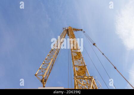 Gru a torre in cantiere. Gru a torre abbassata su sfondo cielo Foto Stock