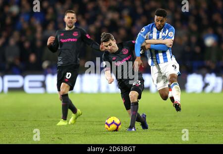 Everton's Seamus Coleman (centro) e Elias Kachunga (destra) di Huddersfield Town combatti per la palla Foto Stock