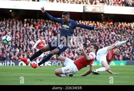 Marcus Rashford (a sinistra) di Manchester United è affrontato da Sokratis di Arsenal Papastathopoulos (centro) Foto Stock