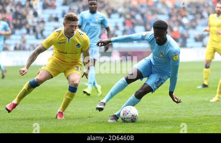 Jordy Hiwula di Coventry City e James Clarke di Bristol Rover (a sinistra) combatti per la palla Foto Stock