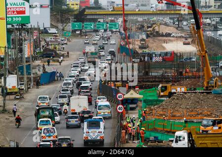 Il traffico pesante che si costruisce in su ad una sezione 2 del progetto della superstrada di Nairobi lungo la strada di Mombasa. Il governo del Kenya sta costruendo la superstrada di Nairobi, un'autostrada a pedaggio lunga 27.1 chilometri destinata a de-congest Nairobi fornendo il trasporto più veloce ed affidabile. La superstrada vale circa 505.5 milioni di dollari e dovrebbe essere completata nel 2022, essendo finanziata dalla Cina nel quadro di un partenariato pubblico-privato (PPP) e costruita dagli appaltatori cinesi, China Road and Bridge Corporation (CRBC). Foto Stock