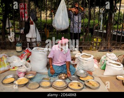 Nuova Delhi, India. 14 ottobre 2020. Un venditore mascherato di strada attende i clienti, come egli vende cereali per uccelli.in India più di 63,509 casi di coronavirus sono stati segnalati in un solo giorno, e 7,239,389 casi confermati di Covid-19 con 110, 586 morti. Credit: Naveen Sharma/SOPA Images/ZUMA Wire/Alamy Live News Foto Stock