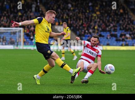 Chris Caden (a sinistra) e Doncaster Rovers'Alfie possono combattere per la palla Foto Stock