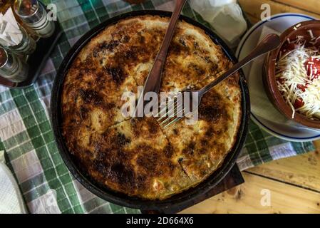 Torta tradizionale serba - pita rossa a strati ripiena di formaggio e cotto in un sacco speciale pentola Foto Stock