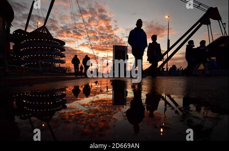 I fan arrivano allo Stadio Etihad mentre il sole tramonta prima della partita Foto Stock