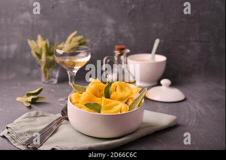 Pasta italiana, ravioli. Tortelloni con salvia aromatica, ricotta e spinaci. Cucina tradizionale bolognese, regione Emilia Romagna. Primo piano. Foto di alta qualità Foto Stock