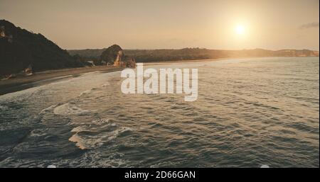 Sole Set mare del golfo oceano roch vista aerea riva. Bella natura paesaggio di isola tropicale in estate sera. Scenario epico di vacanza Indonesia a Sumba Island. Ripresa cinematografica del drone al tramonto Foto Stock